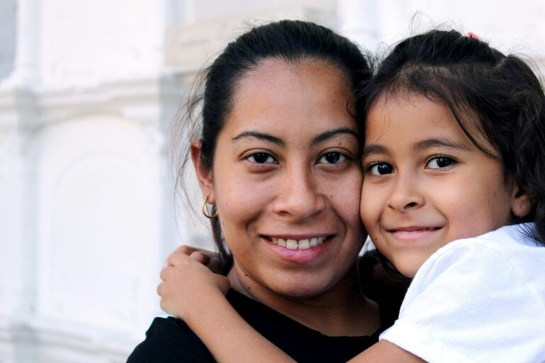 "A loving mother and her daughter sharing a warm embrace and smiling, embodying family support and Miami Mental Health."